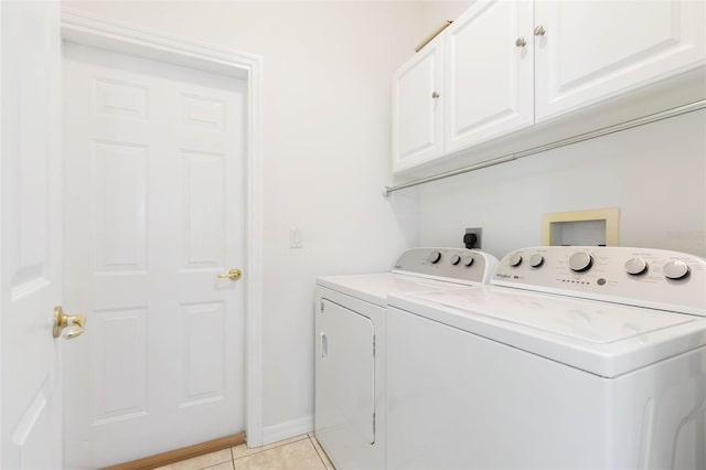 laundry area featuring cabinets, washer and dryer, and light tile patterned floors