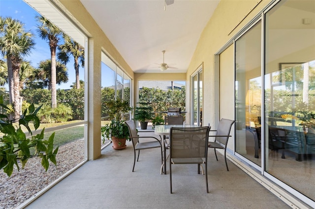 sunroom with ceiling fan and vaulted ceiling