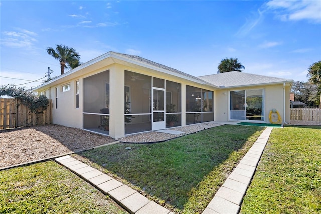 back of house featuring a yard and a sunroom