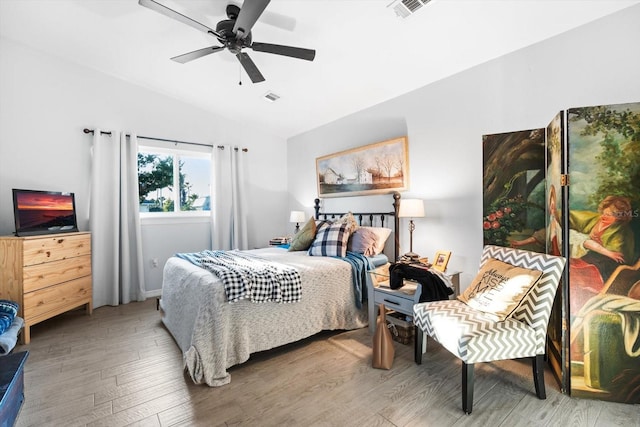 bedroom with hardwood / wood-style flooring, ceiling fan, and vaulted ceiling