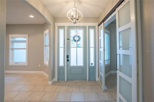 tiled entrance foyer with a chandelier