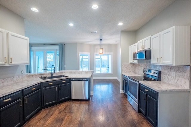 kitchen with pendant lighting, sink, white cabinets, kitchen peninsula, and stainless steel appliances