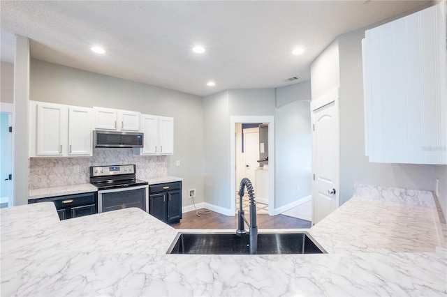 kitchen featuring white cabinetry, sink, decorative backsplash, stainless steel appliances, and dark wood-type flooring