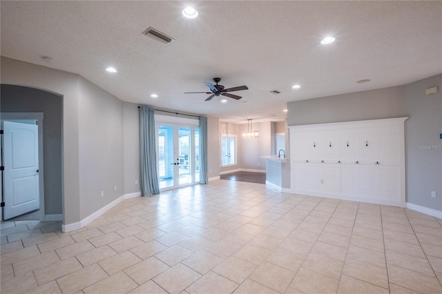 unfurnished room with ceiling fan, light tile patterned floors, a textured ceiling, and french doors