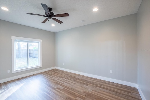 spare room with ceiling fan, a textured ceiling, and light hardwood / wood-style floors