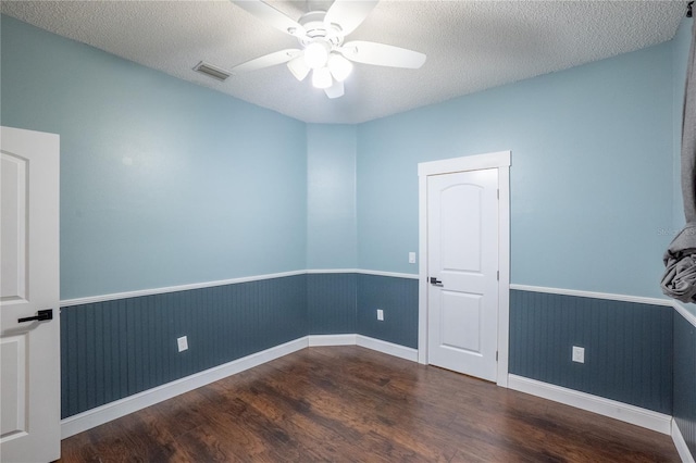 spare room with ceiling fan, dark wood-type flooring, and a textured ceiling