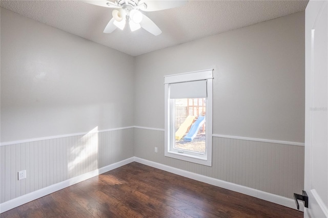 empty room featuring dark hardwood / wood-style flooring, ceiling fan, and a textured ceiling