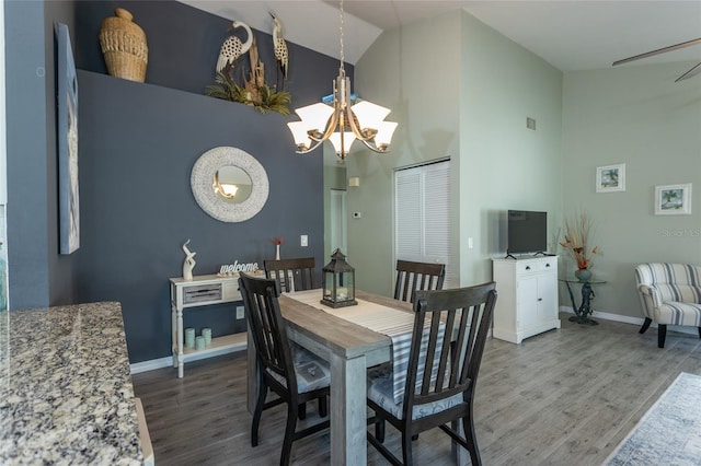 dining space featuring hardwood / wood-style floors, high vaulted ceiling, and a chandelier