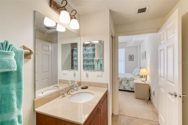 bathroom featuring vanity, tile patterned floors, and a textured ceiling