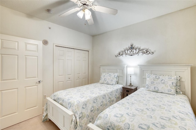 carpeted bedroom featuring ceiling fan and a closet