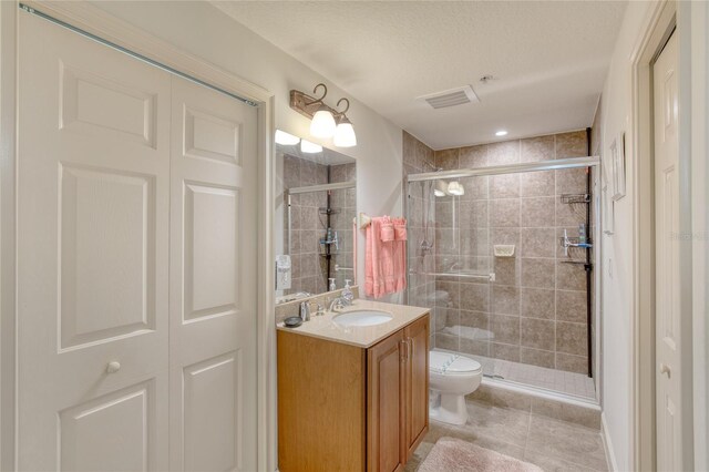 bathroom featuring vanity, tile patterned floors, toilet, and walk in shower