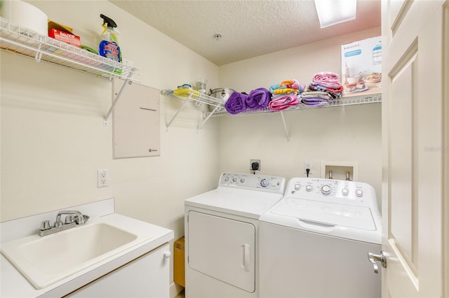 washroom featuring washer and dryer, sink, and a textured ceiling