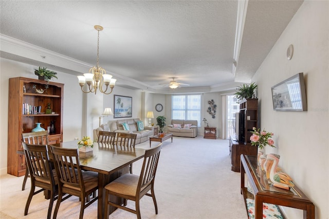 carpeted dining room featuring ceiling fan with notable chandelier, ornamental molding, and a textured ceiling