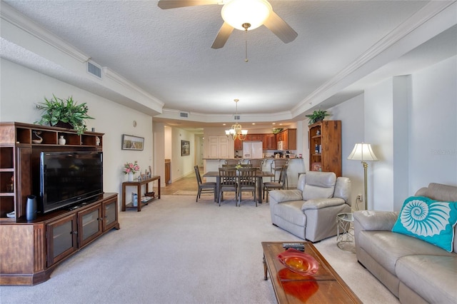 living room featuring crown molding, a textured ceiling, light carpet, ceiling fan with notable chandelier, and a raised ceiling