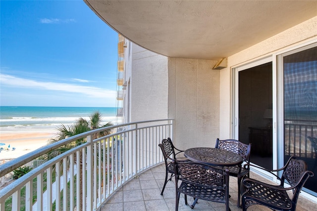 balcony featuring a beach view and a water view