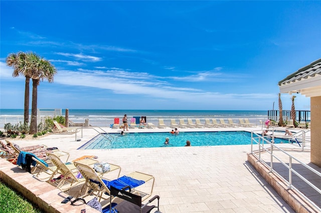 view of swimming pool with a patio and a water view