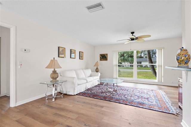 unfurnished living room with wood finished floors, visible vents, and baseboards