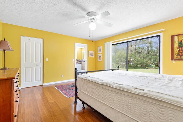 bedroom with access to outside, a textured ceiling, ceiling fan, and wood finished floors