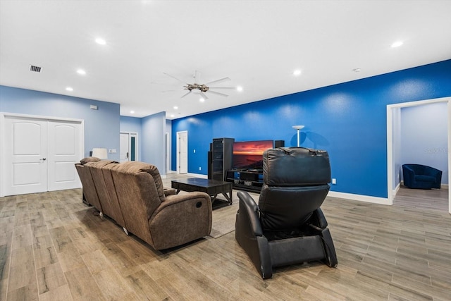 living room with light hardwood / wood-style floors and ceiling fan