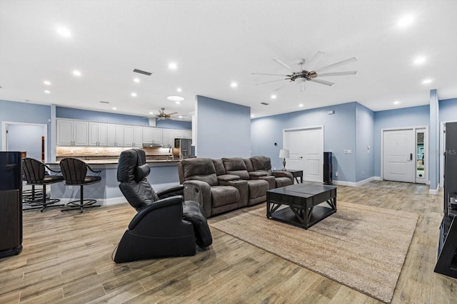 living room featuring ceiling fan and light hardwood / wood-style floors