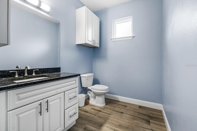 bathroom with hardwood / wood-style flooring, vanity, and toilet