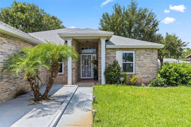 doorway to property featuring a lawn