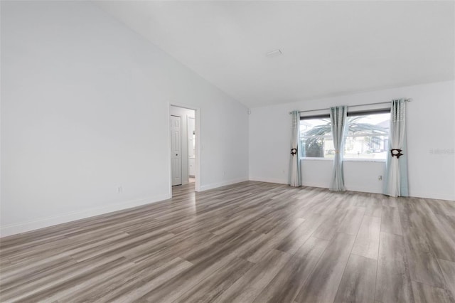 unfurnished room featuring light hardwood / wood-style flooring and high vaulted ceiling