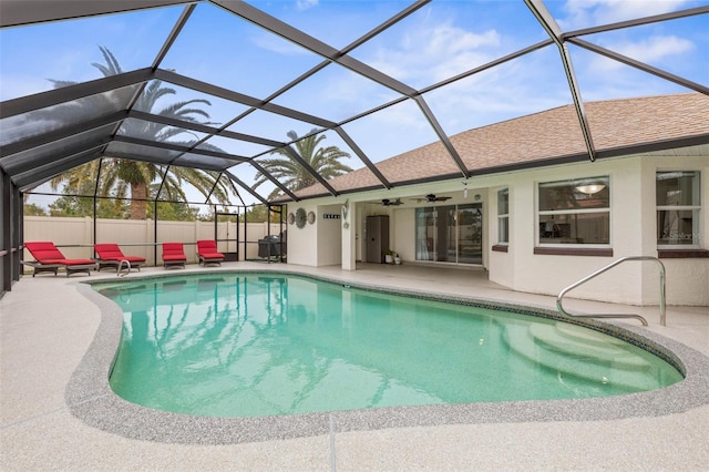 view of pool featuring a patio area, ceiling fan, and glass enclosure