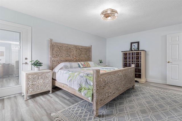 bedroom with hardwood / wood-style floors and a textured ceiling