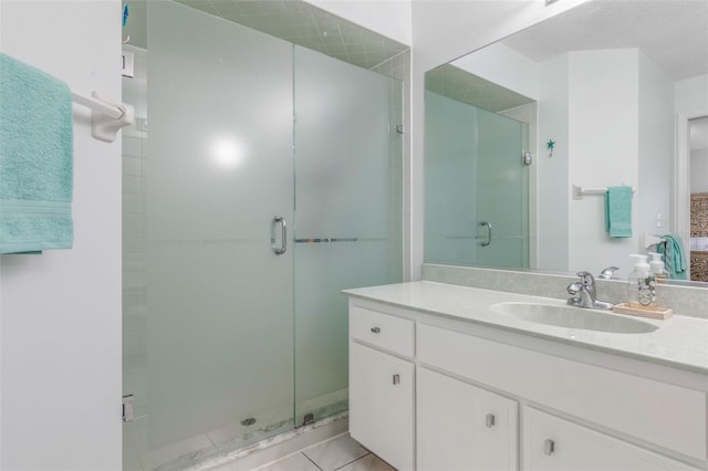 bathroom featuring tile patterned floors, a shower with shower door, and vanity