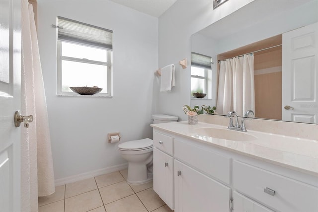 bathroom with vanity, a wealth of natural light, tile patterned floors, and toilet