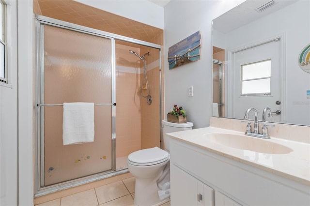 bathroom featuring vanity, a shower with shower door, tile patterned floors, and toilet