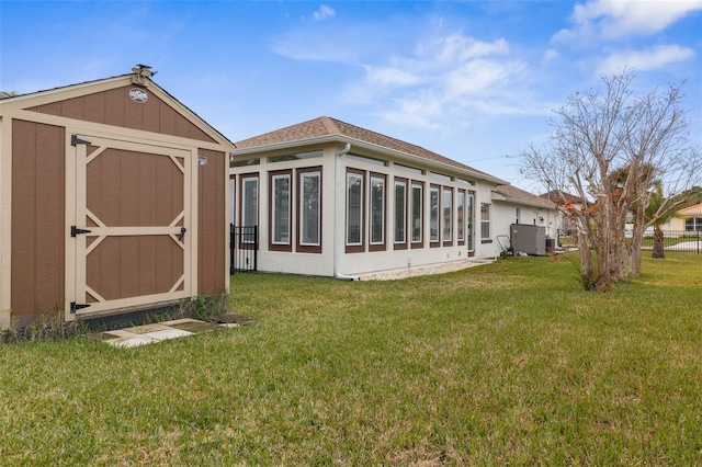 rear view of house featuring a yard and central air condition unit