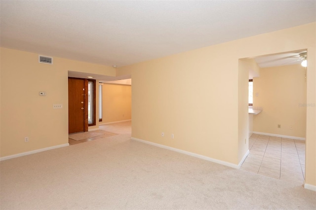 spare room featuring ceiling fan and light colored carpet