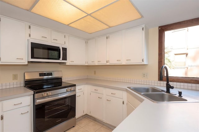 kitchen featuring sink, light tile patterned floors, white cabinets, and stainless steel electric range