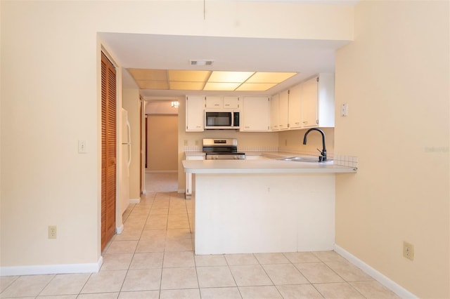 kitchen with light tile patterned flooring, sink, stainless steel electric range oven, kitchen peninsula, and white cabinets