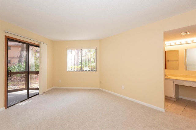 carpeted spare room featuring built in desk