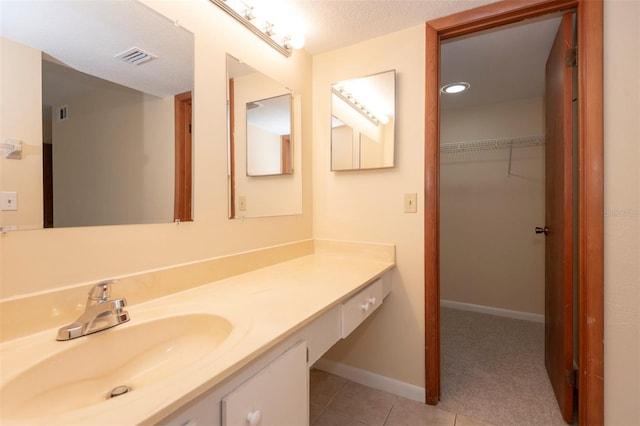 bathroom featuring vanity, tile patterned floors, and a textured ceiling