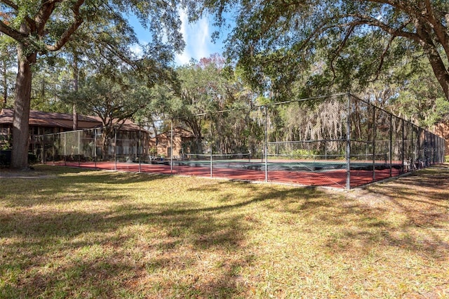 view of tennis court featuring a lawn