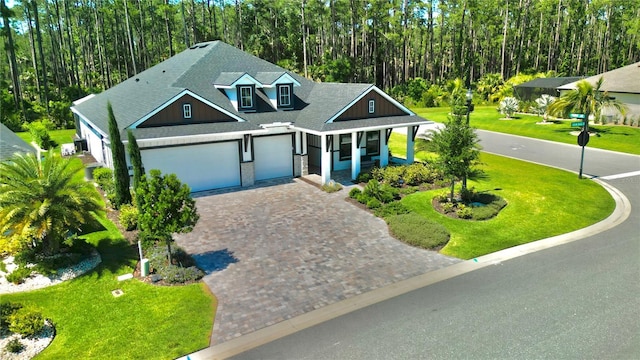 view of front of home featuring a garage, covered porch, and a front lawn