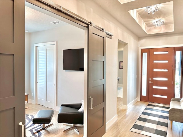 entryway with a barn door and light wood-type flooring