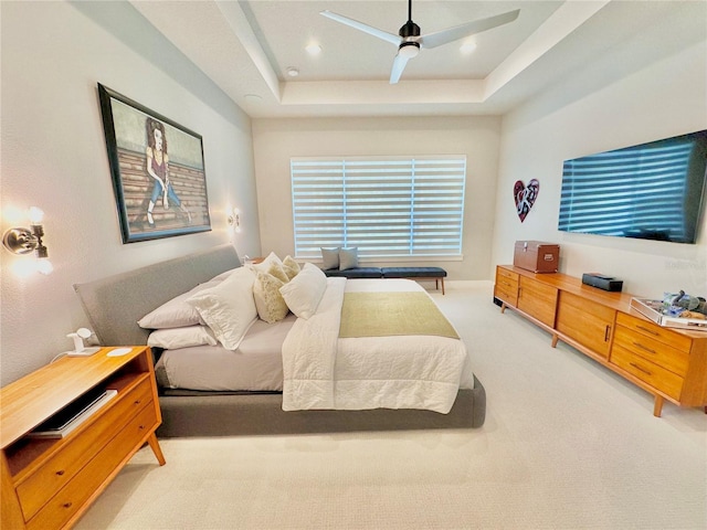 bedroom with carpet flooring, ceiling fan, and a tray ceiling