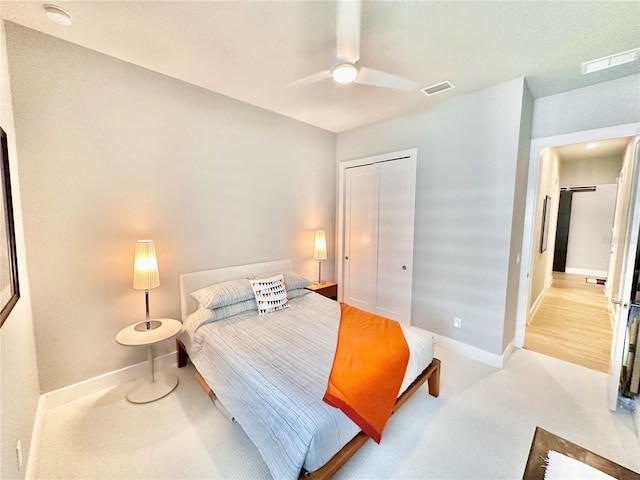 bedroom featuring ceiling fan, light colored carpet, and a closet