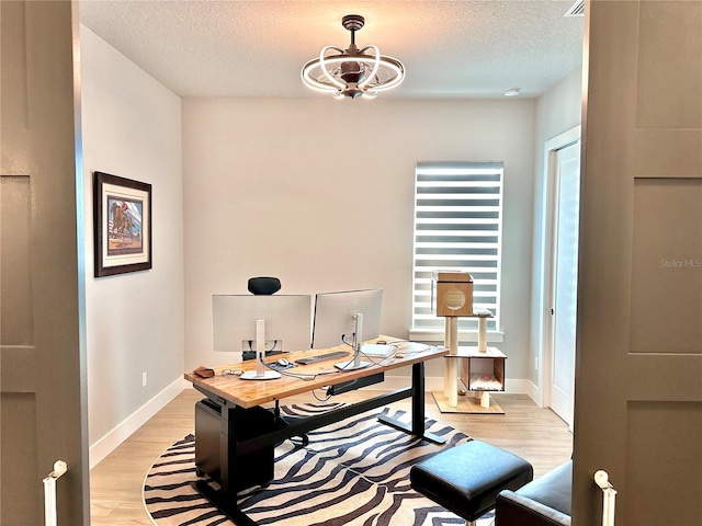 home office featuring a textured ceiling and light wood-type flooring