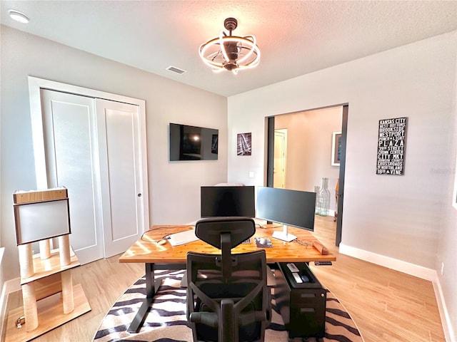 home office featuring a textured ceiling and light wood-type flooring