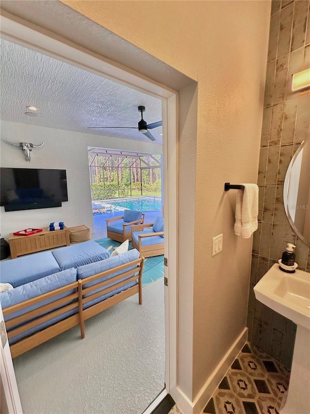 interior space featuring ceiling fan, carpet flooring, and a textured ceiling