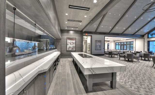 recreation room featuring beam ceiling and a high ceiling