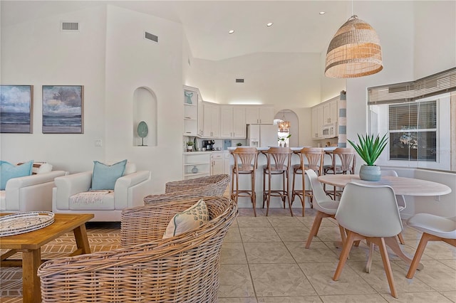 living room with light tile patterned floors and high vaulted ceiling