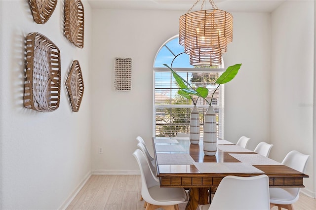 dining area with an inviting chandelier and light hardwood / wood-style floors