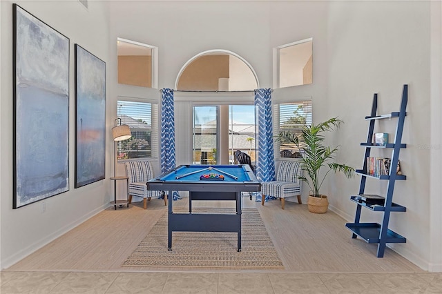 recreation room featuring pool table, tile patterned flooring, and a high ceiling